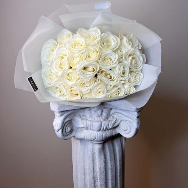 Bouquet of cream white roses wrapped in translucent paper