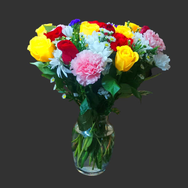 Mixed bouquet of roses, carnations, and daisies in a glass vase