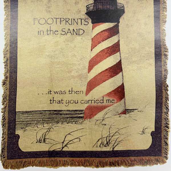 Decorative woven wall hanging with a lighthouse and printed text