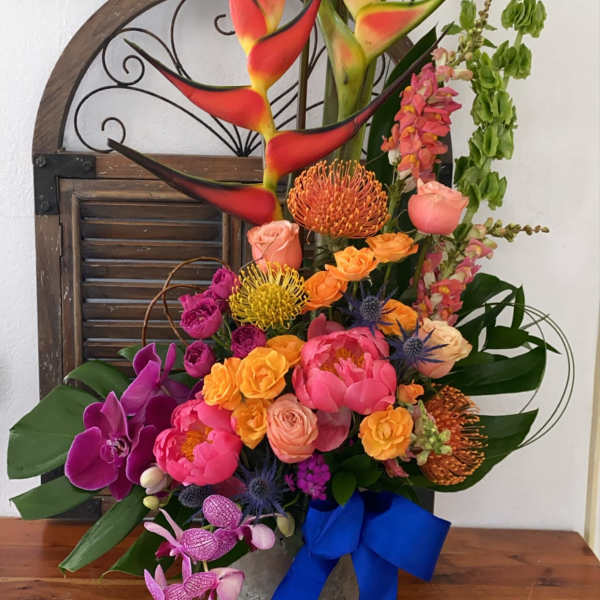 Tall tropical bouquet with orchids, roses, and heliconia in a vase