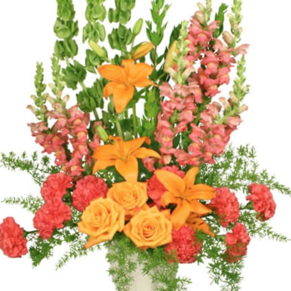 Orange lilies and roses with pink snapdragons in a vase