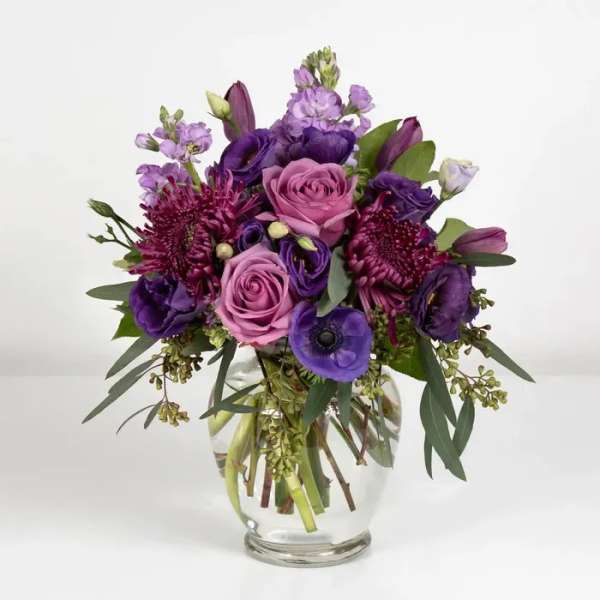 Purple and pink bouquet in a clear glass vase