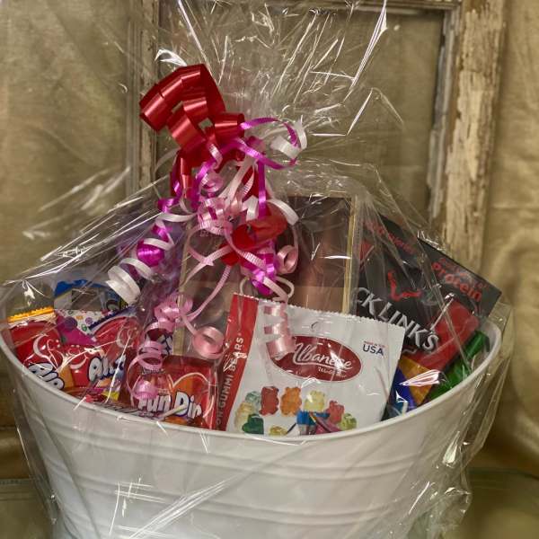 Gift basket with assorted candy and a pink ribbon