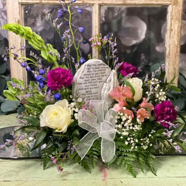 Floral sympathy arrangement with roses, carnations, and a memorial stone