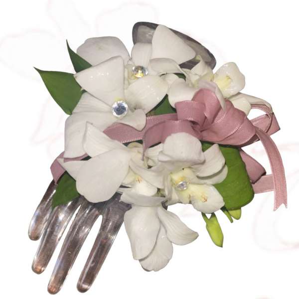 White orchid corsage with pink ribbon and jeweled accents on a clear comb