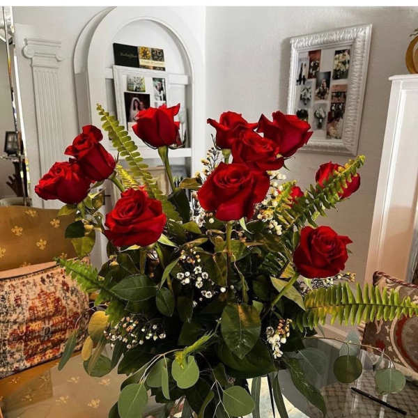 Tall bouquet of red roses in a clear glass vase