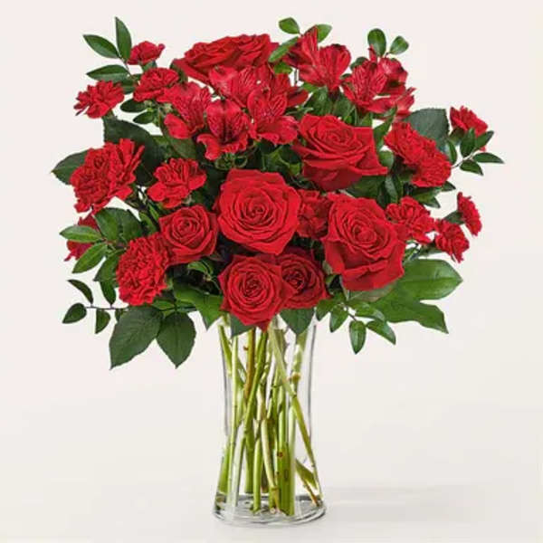 Red roses and carnations in a clear glass vase