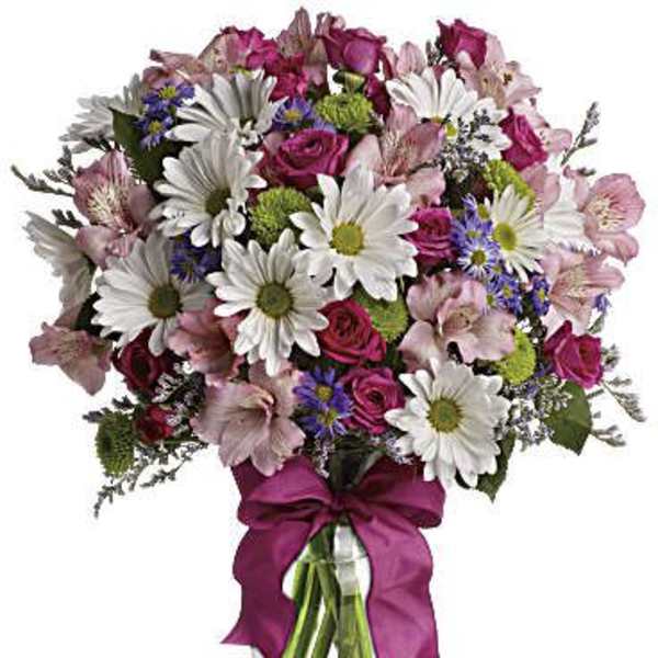 Bouquet of pink and white flowers in a glass vase with a magenta ribbon