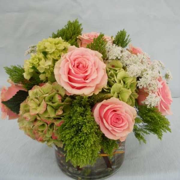Pink roses and green hydrangeas in a glass vase