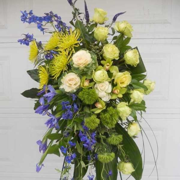 Tall floral spray with yellow, white, and blue flowers on a stand