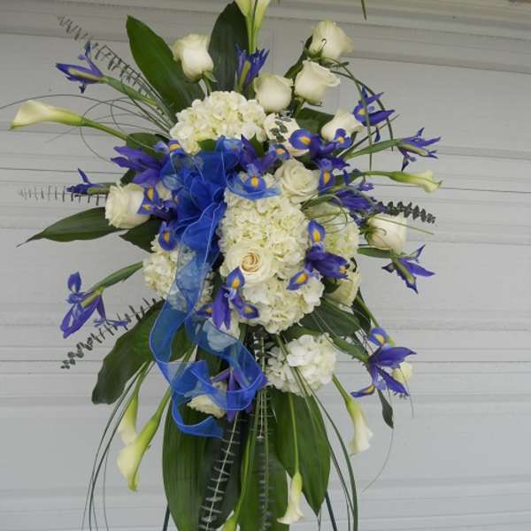 Tall floral spray with white roses, hydrangeas, and blue accents