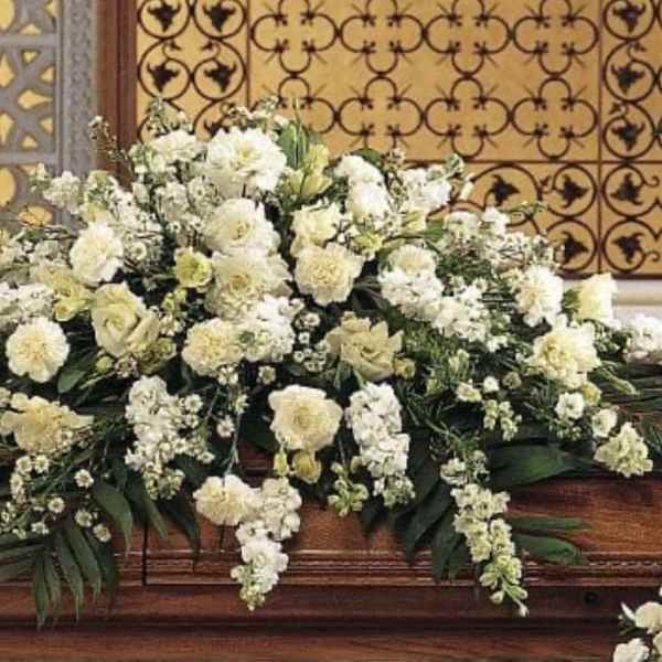 Large white floral casket spray with cascading blooms