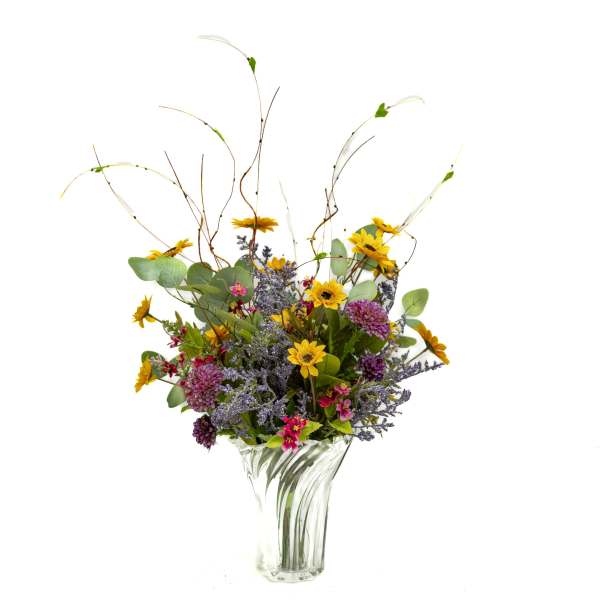 Wildflower bouquet in a clear glass vase with tall curly branches