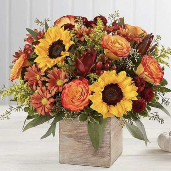 Autumn floral arrangement with sunflowers, roses, and mums in a wooden box