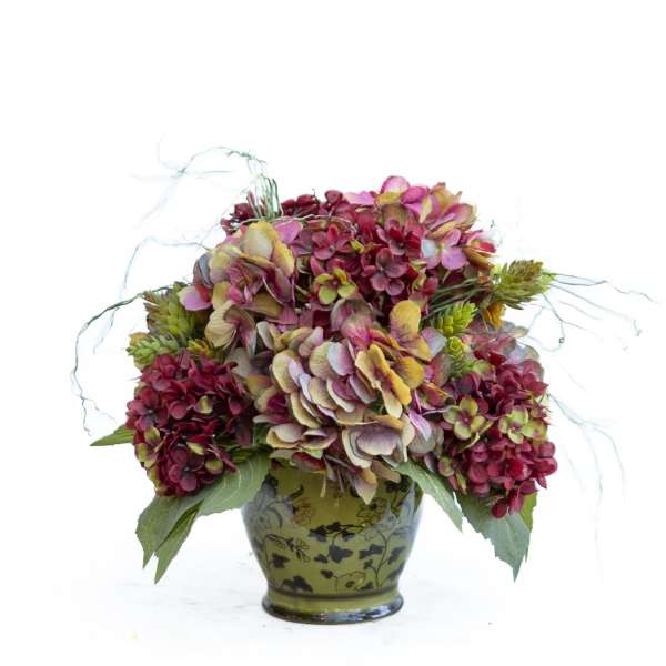 Bouquet of pink and burgundy hydrangeas in a green patterned vase