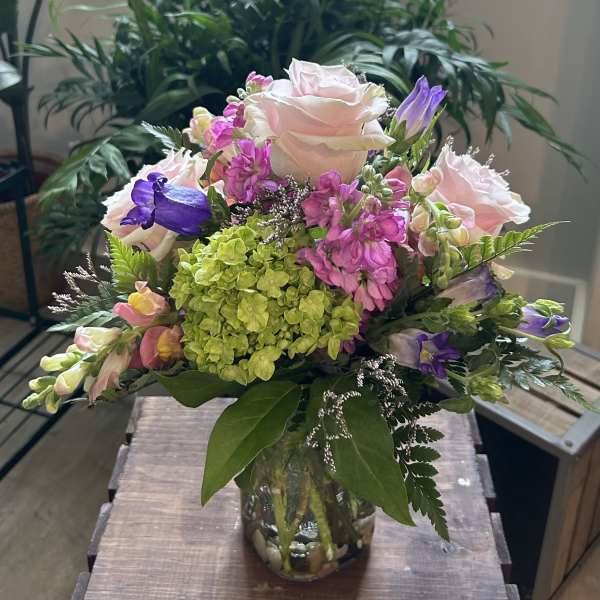Mixed pink and purple flowers in a glass vase