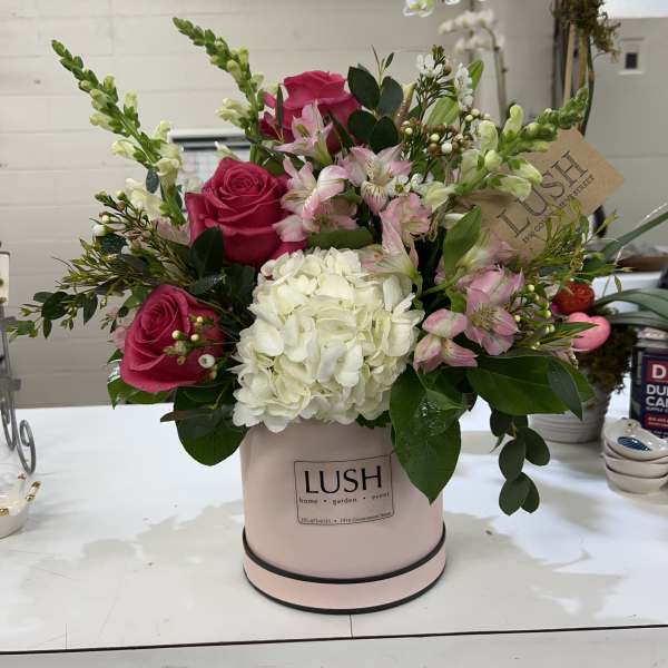 Pink roses and white hydrangea in a blush hatbox with mixed greenery