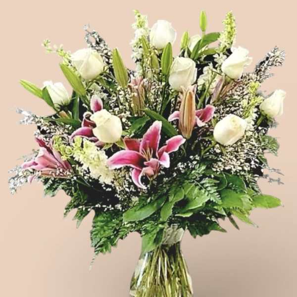 Bouquet of white roses and pink lilies in a clear glass vase