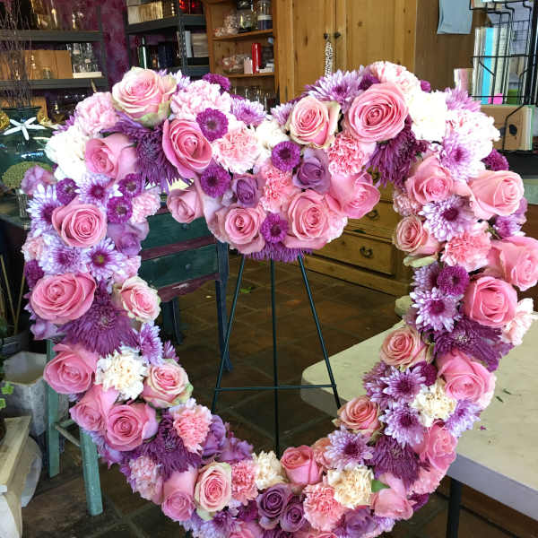 Heart-shaped floral wreath with pink roses and purple flowers