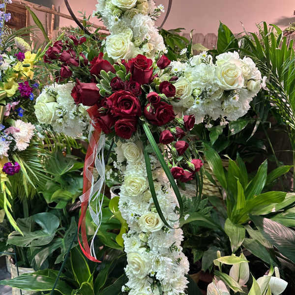 Cross-shaped floral tribute with white and red roses