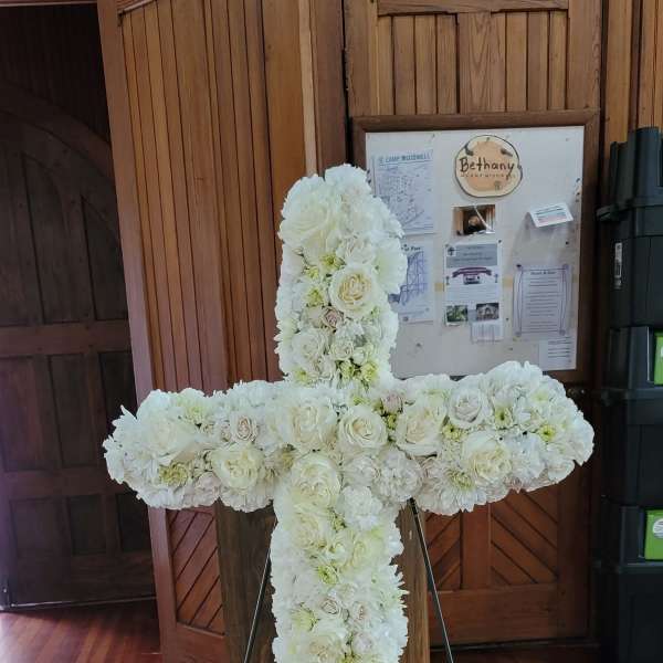 White floral cross on a stand