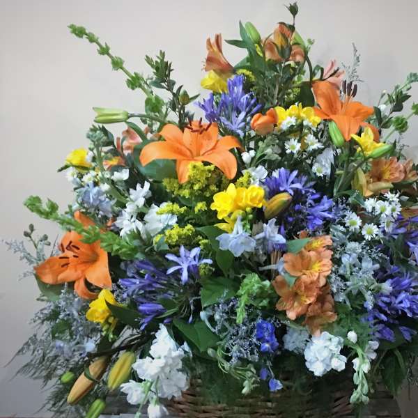 Large mixed bouquet with orange lilies, purple flowers, and yellow blooms