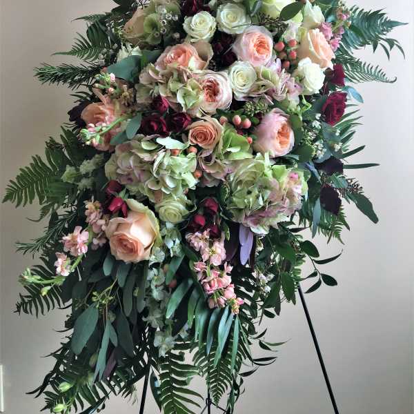 Large standing floral spray with roses, hydrangeas, and greenery