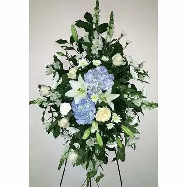 Standing floral spray with white lilies, blue hydrangeas, and white roses