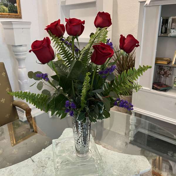 Bouquet of red roses in a silver vase with purple filler flowers
