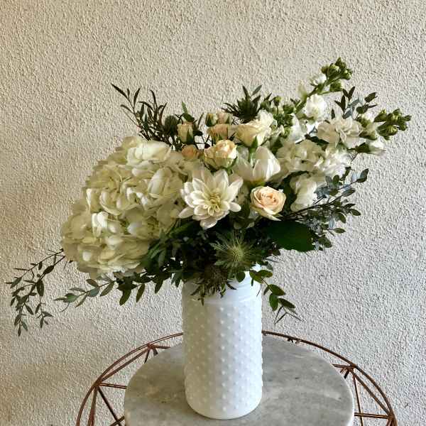 White floral arrangement in a textured white vase