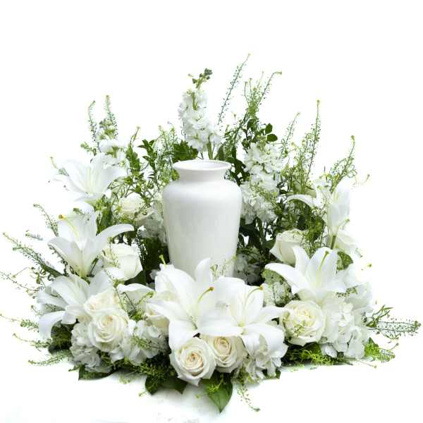 White floral arrangement with lilies, roses, and a white urn vase