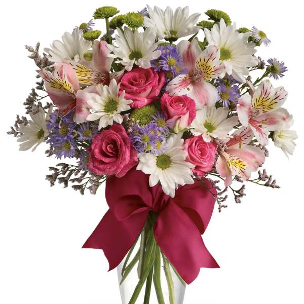 Bouquet of pink roses, white daisies, and alstroemeria in a glass vase with a ribbon