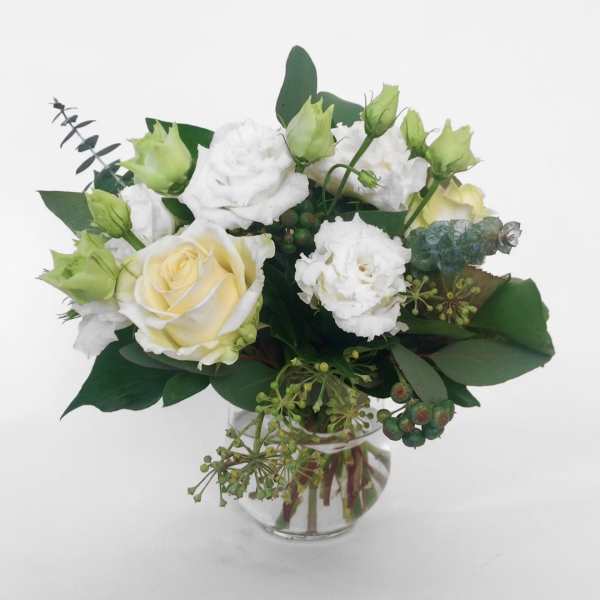 White and pale yellow roses in a clear glass vase
