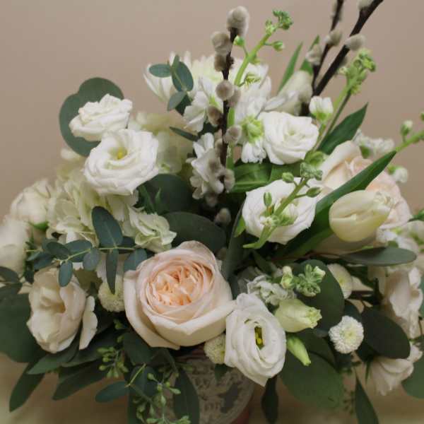 White and blush bouquet with roses and mixed blooms in a vase