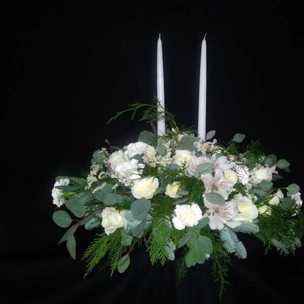White floral arrangement with two tall white candles