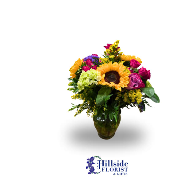 Mixed bouquet with a sunflower and pink roses in a glass vase