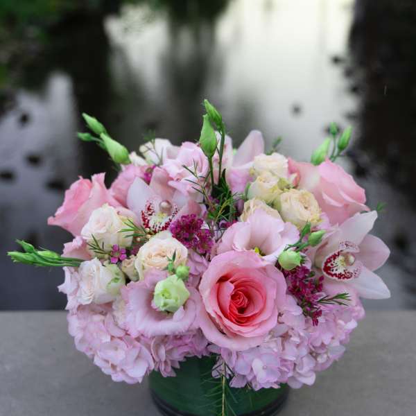 Pink and white floral arrangement in a green vase