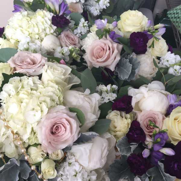 Bouquet of pale roses, white hydrangeas, and purple flowers