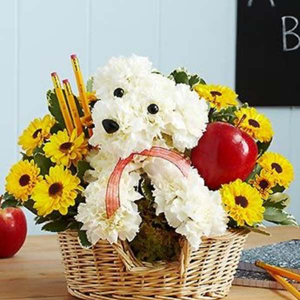 Basket arrangement with a white dog-shaped floral design and yellow daisies