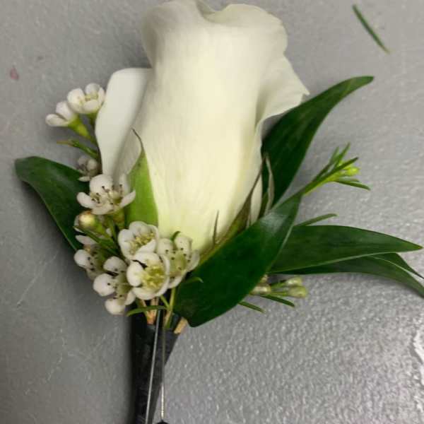 White calla lily boutonniere with small white blossoms and green leaves