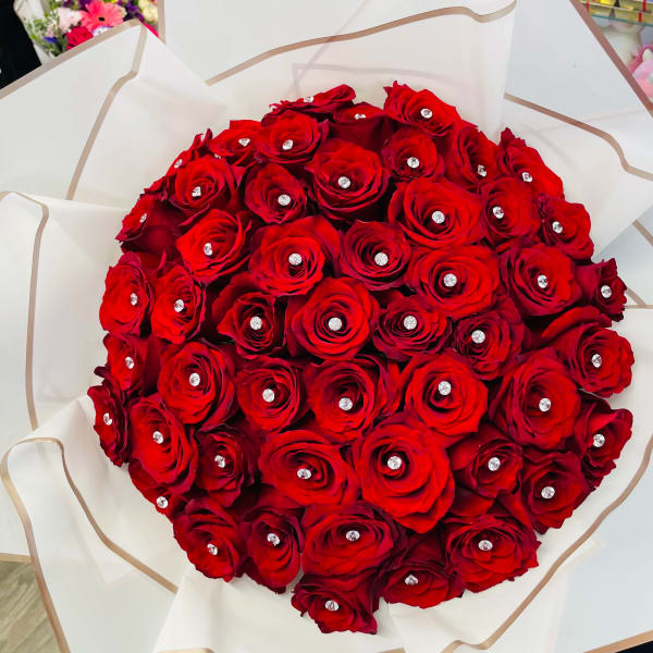 Large bouquet of red roses wrapped in white paper