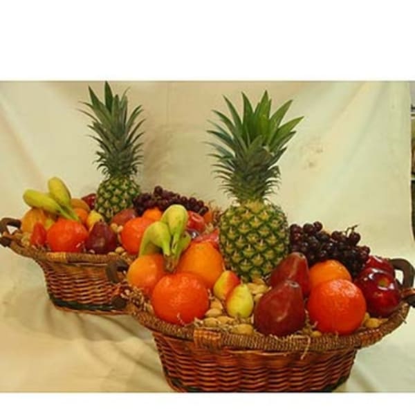 Two fruit baskets with pineapples, grapes, pears, and oranges