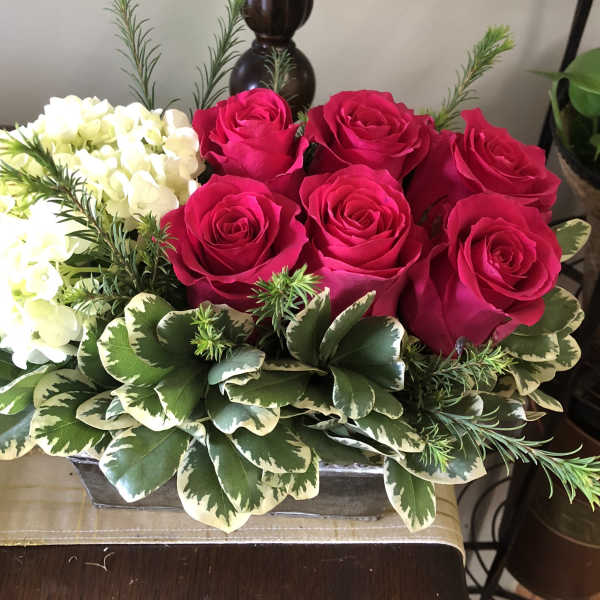 Pink roses and white hydrangeas in a low rectangular container