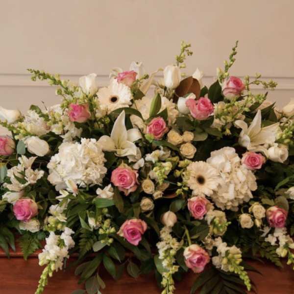 Large white and pink floral casket spray with lilies and roses