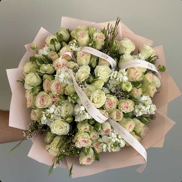 Large bouquet of pale pink and cream roses wrapped in blush paper