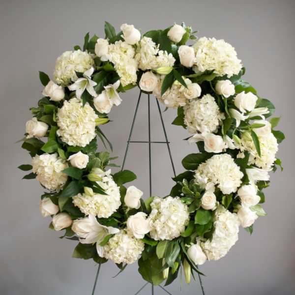 White floral wreath on a metal stand