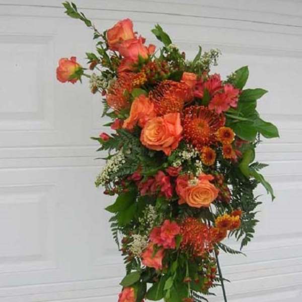Tall orange floral standing spray on an easel