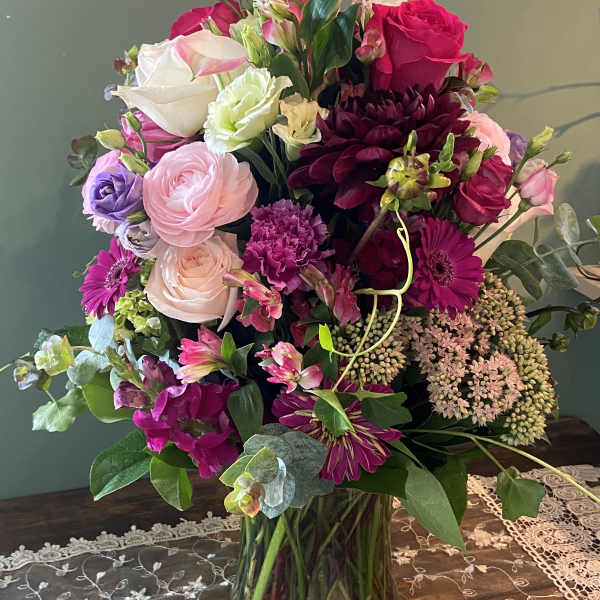 Mixed pink, white, and purple bouquet in a glass vase