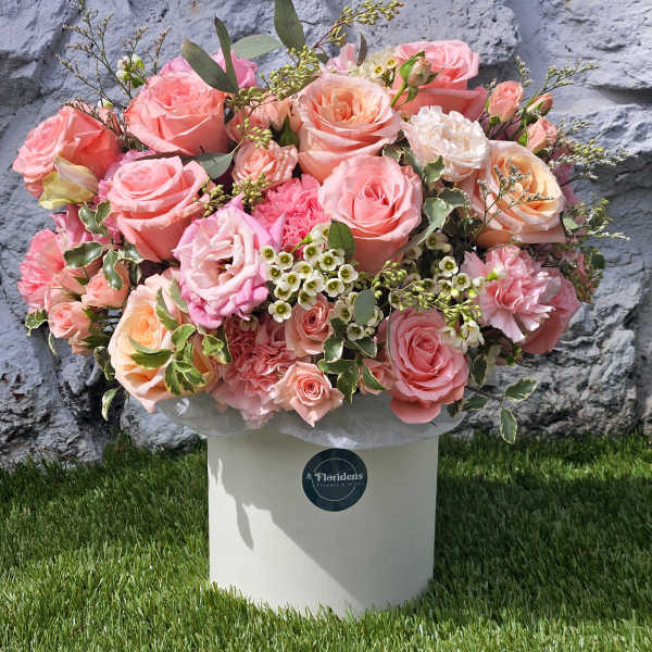 Large bouquet of pink and peach roses in a white box