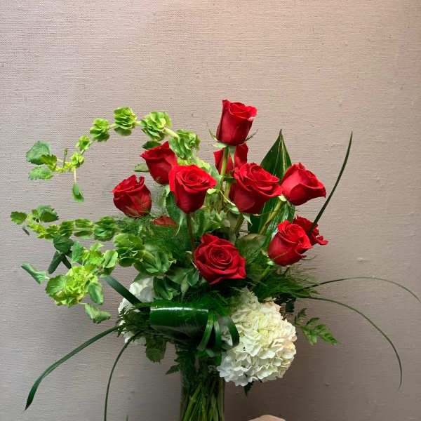 Red roses and white hydrangeas in a clear glass vase